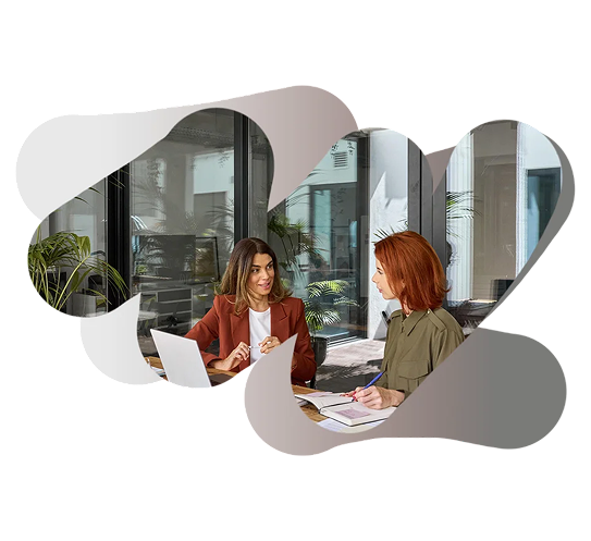 Dos mujeres conversando en una reunión de trabajo.